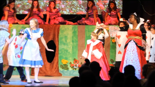 Une capture d'écran de mauvaise qualité de la comédie musicale Alice in Wonderland Jr interprétée par la Oliver Middle School en 2014